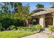 Charming brick home featuring an arched portico, lush landscaping, and brick driveway at 2220 Edison Ave, Atlanta, GA 30305