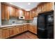 Cozy kitchen with wood cabinets, granite counters, a black refrigerator, and hardwood floors at 2220 Edison Ave, Atlanta, GA 30305