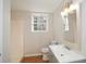 Updated bathroom with a wide sink, window view and neutral tile flooring near the toilet at 3667 Humphries Hill Rd, Austell, GA 30106