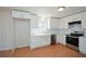 Well-lit kitchen with white cabinets, updated appliances, and a farmhouse sink at 3667 Humphries Hill Rd, Austell, GA 30106