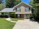 Two-story house with tan siding, brick accents, and a driveway at 6048 Old Wellborn Trce, Lithonia, GA 30058