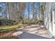 Backyard with brick patio, green grass, and trees around the perimeter at 450 Surveyors Pt, Suwanee, GA 30024