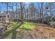 Backyard with stone retaining walls, some green grass and privacy hedges at 450 Surveyors Pt, Suwanee, GA 30024