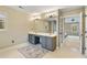 Bright bathroom with a double sink vanity, a large mirror with decorative lights and a connecting door at 450 Surveyors Pt, Suwanee, GA 30024