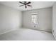 A spacious bedroom with white walls, neutral carpet, and a window that provides natural light at 450 Surveyors Pt, Suwanee, GA 30024