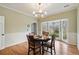 Dining area featuring wood floors, bay window and modern chandelier fixture at 450 Surveyors Pt, Suwanee, GA 30024