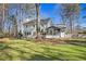 Exterior of home featuring a backyard with green grass, a sunroom and a patio at 450 Surveyors Pt, Suwanee, GA 30024