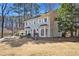 Front exterior of the home with a lawn and mature trees at 450 Surveyors Pt, Suwanee, GA 30024