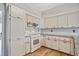 Spacious kitchen featuring white cabinets, stainless steel appliances, tile backsplash and hardwood floors at 450 Surveyors Pt, Suwanee, GA 30024