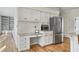 Bright kitchen area with stainless steel appliances, granite counters, white cabinets, and hardwood flooring at 450 Surveyors Pt, Suwanee, GA 30024