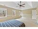 Spacious main bedroom with a ceiling fan, neutral walls, carpeted floor and natural light from the multiple windows at 450 Surveyors Pt, Suwanee, GA 30024