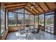 Enclosed sunroom with wood ceiling, ceiling fan, table and view of backyard at 450 Surveyors Pt, Suwanee, GA 30024