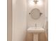 Small powder room with pedestal sink and round mirror at 958 Moda Dr, Atlanta, GA 30316