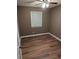 Simple bedroom with wood-look flooring, neutral walls, and ceiling fan at 2320 Cherokee Valley Dr, Lithonia, GA 30058