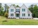 Two-story white brick home with a gray roof and green door at 6585 Rhett Run, Cumming, GA 30028