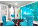 Dining area with a glass top table, turquoise velvet chairs and modern wall art at 218 Ward Rd, Ellenwood, GA 30294