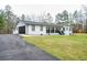 Charming white brick home with black accents, two-car garage, and spacious lawn at 218 Ward Rd, Ellenwood, GA 30294