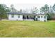 Charming white brick home with black accents, front porch, and spacious lawn at 218 Ward Rd, Ellenwood, GA 30294