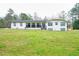 Charming home with a large front lawn, covered porch, and a freshly painted white exterior at 218 Ward Rd, Ellenwood, GA 30294