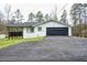 Charming white brick home with black accents, two-car garage, and spacious driveway at 218 Ward Rd, Ellenwood, GA 30294