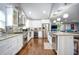Stylish kitchen boasts white cabinets, granite counters, stainless appliances, and an island that opens to living space at 218 Ward Rd, Ellenwood, GA 30294