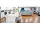 Open-concept kitchen with stainless steel appliances and island seating flows into a modern living space at 218 Ward Rd, Ellenwood, GA 30294