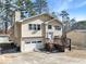 Tan two-story house with attached garage and deck at 5737 Riverside Dr, Sugar Hill, GA 30518