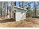 Exterior view of a well-maintained storage shed in a wooded setting at 5737 Riverside Dr, Sugar Hill, GA 30518