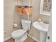 Neat bathroom features a toilet, a pedestal sink, and convenient storage shelving at 6460 Boca Grande Blvd, Forest Park, GA 30297