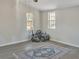 Neutral bedroom with wood-look flooring, two windows, and a decorative rug at 6460 Boca Grande Blvd, Forest Park, GA 30297