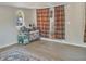 Open living area with wood-look flooring, curtains, and a large play area at 6460 Boca Grande Blvd, Forest Park, GA 30297