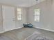 Spare room featuring two windows and a door, with a patterned rug on the gray floor at 6460 Boca Grande Blvd, Forest Park, GA 30297