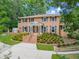 Brick two-story house with landscaped yard, large driveway, and a stately entrance at 1195 Old Woodbine Rd, Atlanta, GA 30319