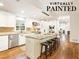 White kitchen with granite island, stainless steel appliances, and hardwood floors at 1195 Old Woodbine Rd, Atlanta, GA 30319