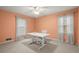 Bedroom with peach walls, two windows, and a built-in workspace at 4086 Pecan Nw Ct, Lilburn, GA 30047