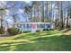 Ranch style home with blue exterior, pink door, and spacious lawn at 4086 Pecan Nw Ct, Lilburn, GA 30047