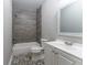 Updated bathroom features gray tile, a bathtub, and a white vanity at 2711 Glenwood Se Ave, Atlanta, GA 30317