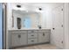 Well-lit bathroom featuring a double sink vanity with gray cabinets and modern fixtures at 261 Dahlia Dr, Woodstock, GA 30188