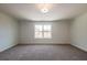 Bright bedroom with neutral carpet and large window overlooking a treed yard at 261 Dahlia Dr, Woodstock, GA 30188