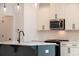 A modern kitchen featuring white cabinetry, stainless steel appliances, and a stylish island with pendant lighting at 261 Dahlia Dr, Woodstock, GA 30188