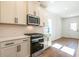 Open kitchen with stainless steel microwave and oven and featuring a white backsplash at 261 Dahlia Dr, Woodstock, GA 30188