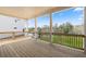 Covered back porch with wooden deck, white pillars, and a view of the trees and backyard at 5247 Flannery Chase Sw, Powder Springs, GA 30127