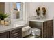 Bathroom featuring double vanity, white countertop, dark wood cabinets, and decorative elements at 5247 Flannery Chase Sw, Powder Springs, GA 30127