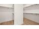 Spacious walk-in closet with hardwood floors, white walls, and built-in shelving at 5247 Flannery Chase Sw, Powder Springs, GA 30127