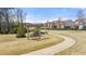 A bench swing sits along a curved sidewalk through a community park on a clear day at 5247 Flannery Chase Sw, Powder Springs, GA 30127