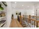 Upstairs hallway with hardwood floors, wooden railing, and a decorative bookcase at 5247 Flannery Chase Sw, Powder Springs, GA 30127