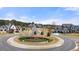 A neighborhood roundabout is landscaped with plants and flowers; upscale homes are in the background at 5247 Flannery Chase Sw, Powder Springs, GA 30127