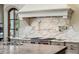 Close up on kitchen featuring white marble backsplash, stone countertops, and chef-grade Wolf range at 2631 Habersham Nw Rd, Atlanta, GA 30305