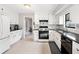 Well-lit kitchen with white cabinetry, granite countertops, and modern appliances, creating a functional and stylish cooking area at 749 Scarlet Ne Dr, Kennesaw, GA 30144