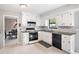 Bright kitchen with white cabinets, black countertops, and stainless steel appliances offers a clean, modern space at 749 Scarlet Ne Dr, Kennesaw, GA 30144